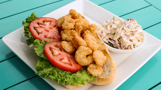 Fried shrimp sandwich with a side of coleslaw.