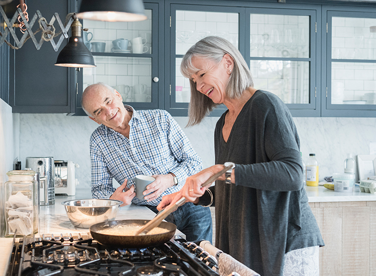 Two older people cooking