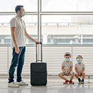 Father with children at airport wearing masks