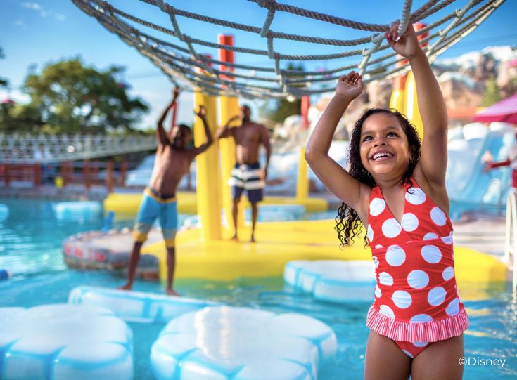 Girl hanging on net above water at a Disney water park. Girl hanging on net above water at a Disney water park.