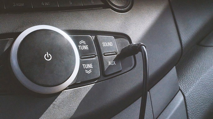 An audio aux in cable plugged into a car radio