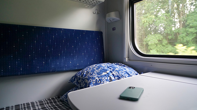 A bed in a sleeper cabin on a train. 