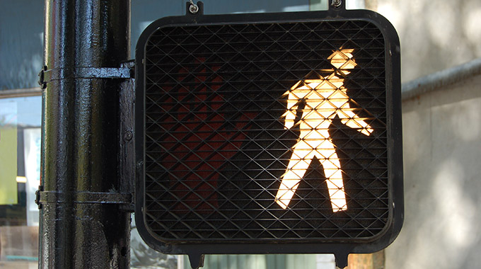 Crosswalk sign displaying the walk symbol
