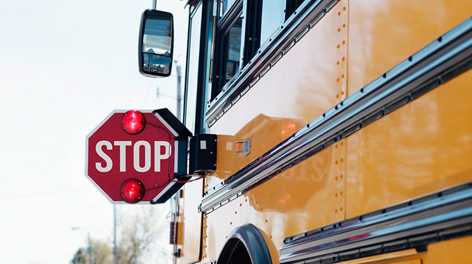 A school bus with the flashing stop sign deployed