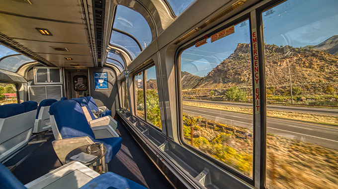 The view from a train's observation car, with floor-to-ceiling windows.