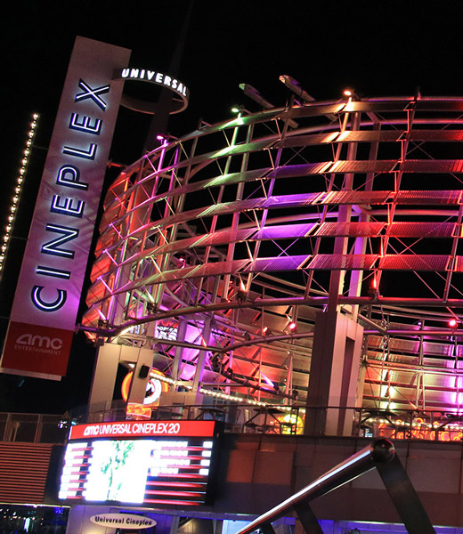 Colorfully lit exterior of the AMC Universal Cineplex 20 movie theater