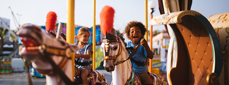 865032364 Kids On Theme Park Carousel 735x275 