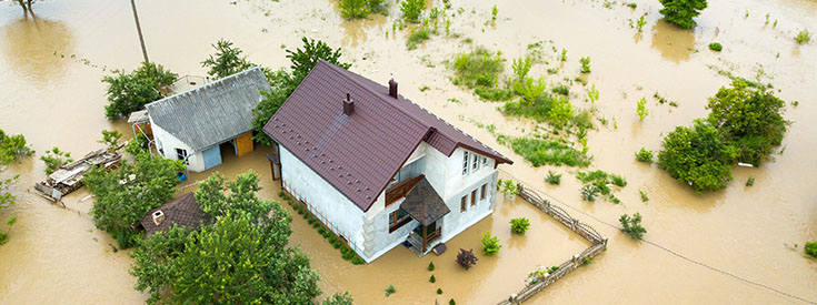 Aerial view of a home in dirty floodwater Aerial view of a home in dirty floodwater