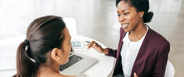 Agent reviewing paperwork with a client at a table Agent reviewing paperwork with a client at a table