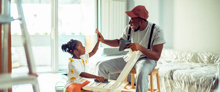 Man and daughter high five while cleaning a chair Man and daughter high five while cleaning a chair