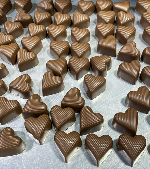 A tray of chocolate-covered heart-shaped candies.