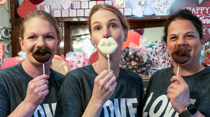 Nandy's Candy employees holding up candy lips.