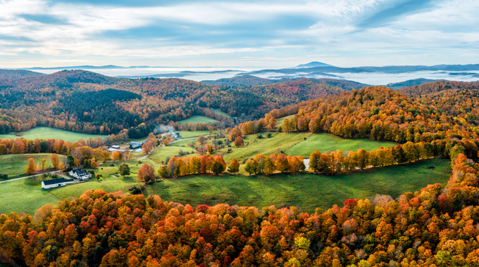 Aerial view of fall foliage framing Cloudland Farm. 