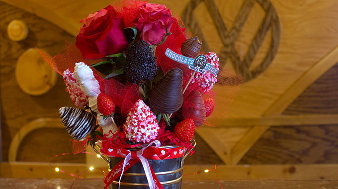A bouquet of chocolate-covered strawberries and roses
