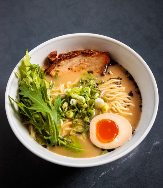 Bowl of shoyu ramen topped with green onions and an egg.