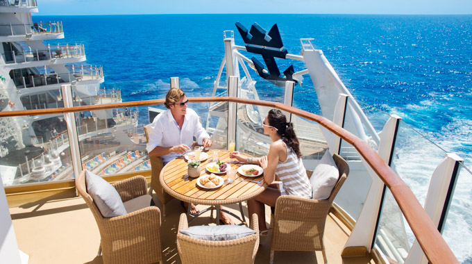 Couple dining on the AquaTheater Suite balcony on the Allure of the Seas