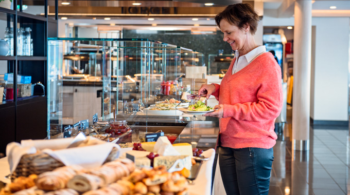 Woman filling her food at a buffet.