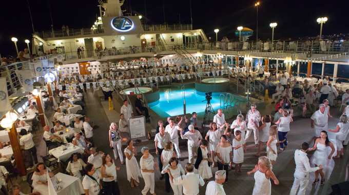 Guests clad in all white dancing aboard an Azamara ship