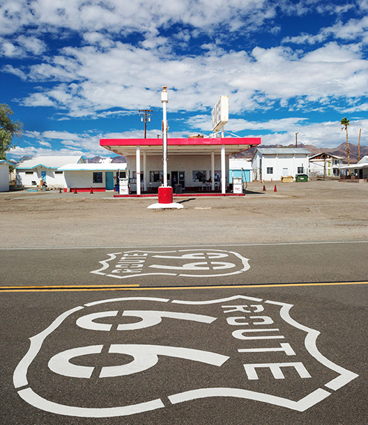 Route 66 painted on the road beside an old gas station