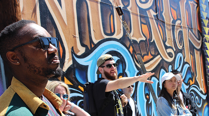 Group in front of street art on a building.