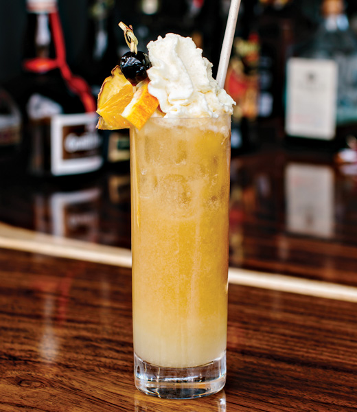 Wai Kai Mai Tai cocktail topped with whipped cream and an orange slice.