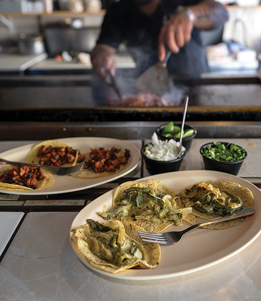 Plates with veggie and al pastor tacos. 