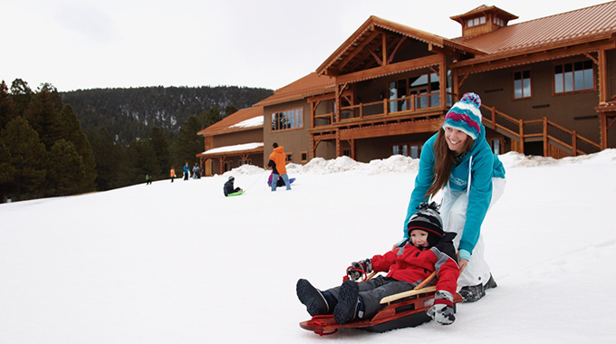 A woman guiding a young sledder