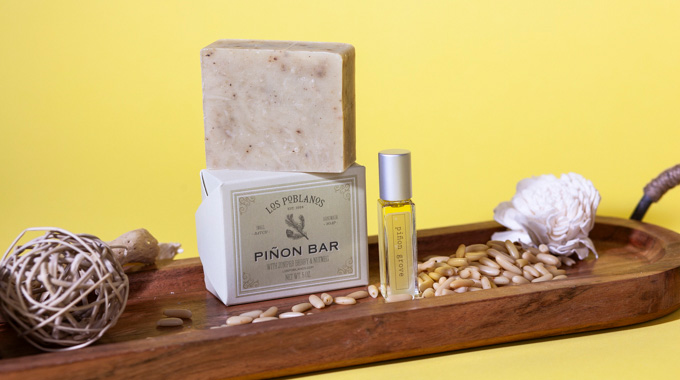 Bar of piñon soap beside a vial of piñon essential oil