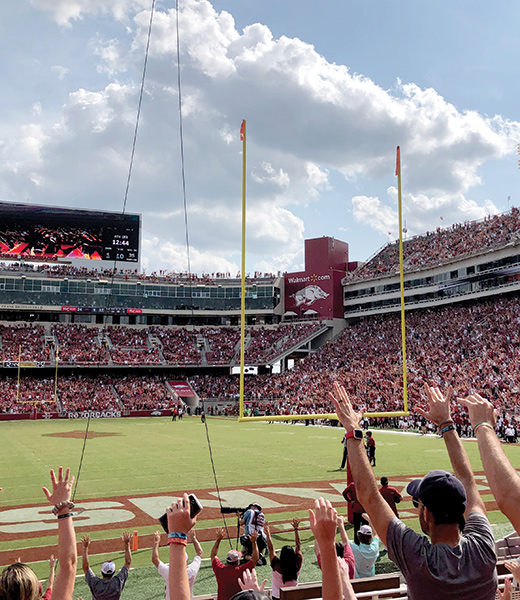 University of Arkansas fans raising their arms in a Hog Call.