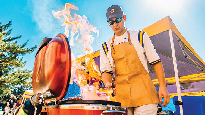 Man grilling at LSU tailgate party.