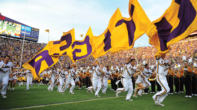 Louisiana State University colorguard, marching band, and cheerleaders on the field.