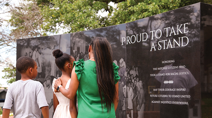 Visitors looking at the Proud to Take a Stand monument.