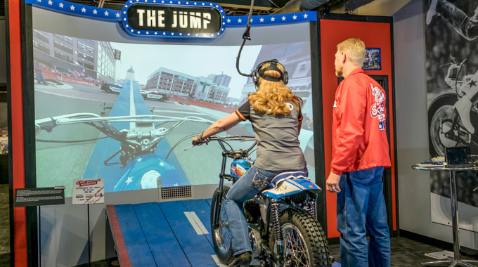 Museum visitor on a virtual motorcycle jump simulator