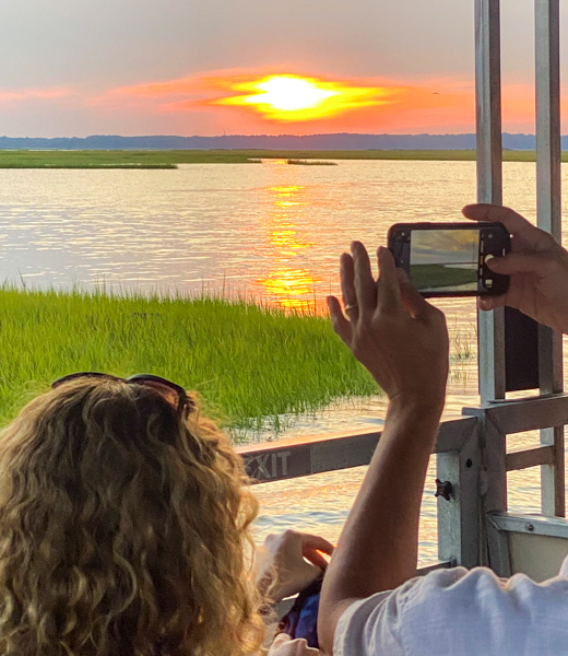 Passengers snapping a photo of a Virginia Beach sunset.