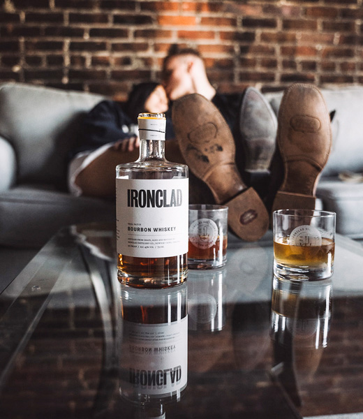 Ironclad Distillery bourbon cocktail, with a couple shown in the background.