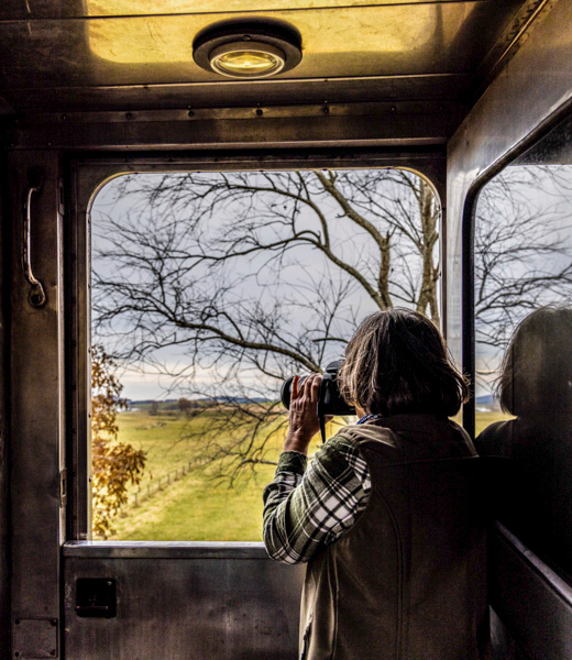 Woman photographing the scenery from inside the train